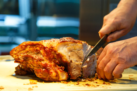 A chef slices roast meat. A good illustration for meat, meat restaurant and catering.の写真素材