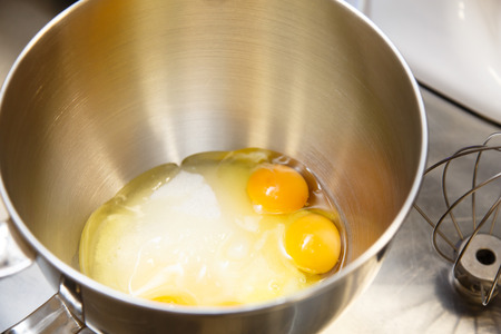 The eggs and sugar in the bowl of a blender before whipping.の写真素材
