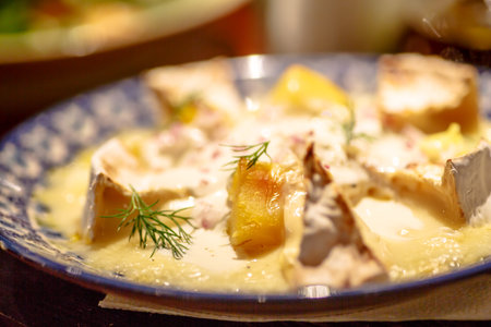Melted Camembert on a plate with dill.