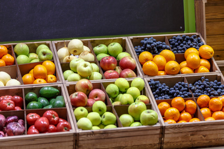 Apples, oranges, grapes, pears, and other fruits and vegetables lying on the counter of the store.の写真素材