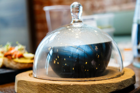 Fish tomato soup in a plate under a glass bell Cloche.の写真素材