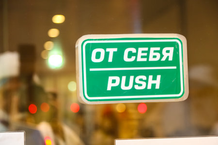 Sign push in Russian and English on the glass door, behind which some lights.
