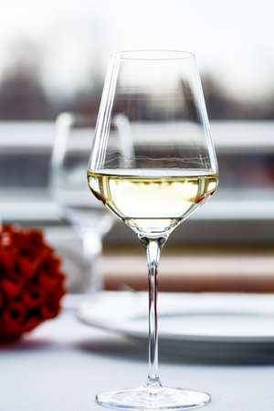 A glass of white wine stands on the table in the restaurant.の写真素材