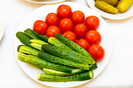 Fresh cucumbers and tomatoes on the plate.の写真素材