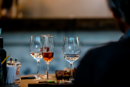 Silhouettes of people sitting at a table in the restaurant. On the table plates glasses.の写真素材