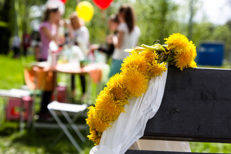 Wreath of yellow dandelions lying on benches, picnicの写真素材
