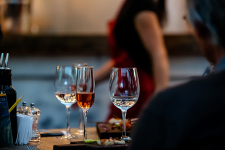 Silhouettes of people sitting at a table in the restaurant. On the table plates glasses.