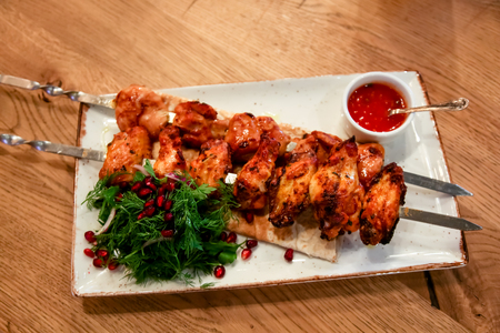 Chicken kebab with tomato sauce, herbs and pomegranate seeds.の写真素材