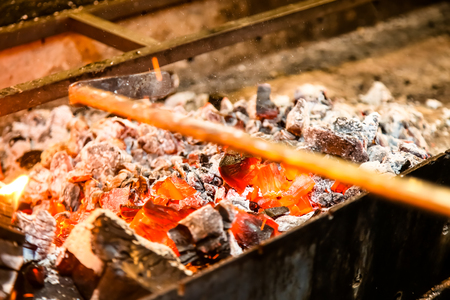 The coals are prepared for grilling the skewers.の写真素材