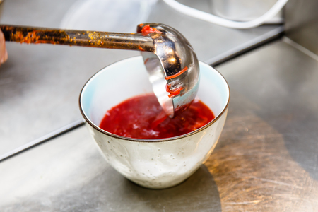 The cook pours soup in a bowl.の写真素材