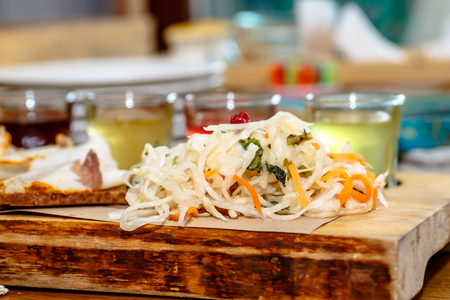 Traditional Russian snacks: cabbage, cucumbers and alcoholic drinks are on the table.の写真素材