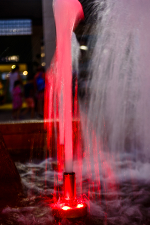 Red fountain in the Park at nightの写真素材
