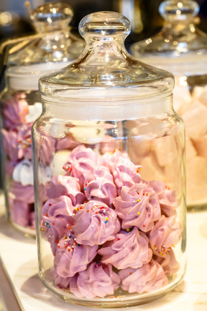 Marshmallows and biscuits lies in a glass jar for candies.の写真素材