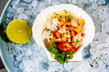 Ceviche of scallop and salmon in the sink from the scallop on iceの写真素材