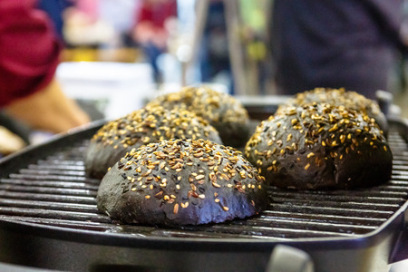 The chef prepares the Burger black buns on the grillの写真素材