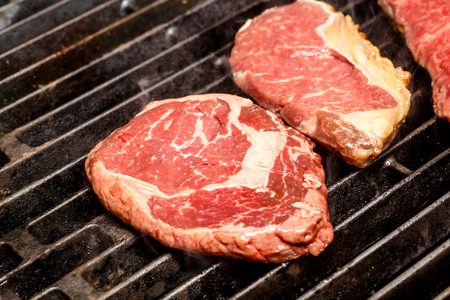 The chef cooks steaks on the grill.の写真素材