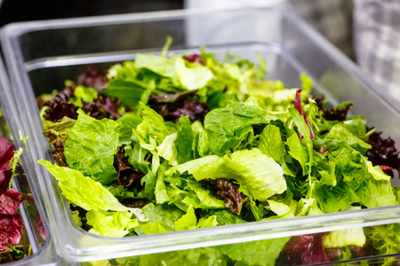 The colored leaves of lettuce are in the containerの写真素材