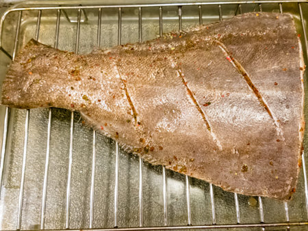 The portion of halibut prepared for roasting on the grill.