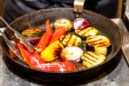Grilled vegetables are fried on a frying pan: pepper, zucchini, onion.の写真素材