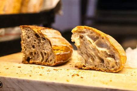 Fresh homemade bread ( rye and wheat) slices lie on the table.