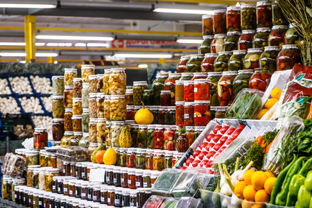 Glass jars with canned vegetables and fruits on the market.の写真素材