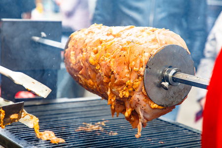 The chef cooks Shawarma (Doner kebab) on the spit and cut it into portions.の写真素材