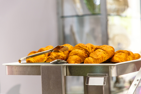 Fresh croissants are on the counter of a pastry shop.の写真素材