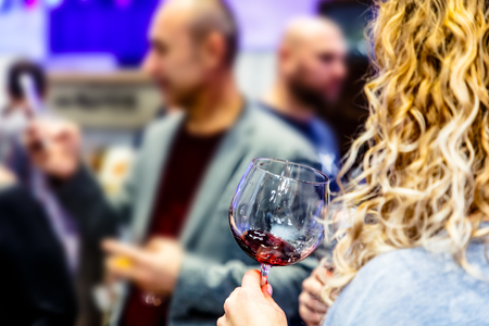 Glass of wine in the hands of the girl at the partyの写真素材