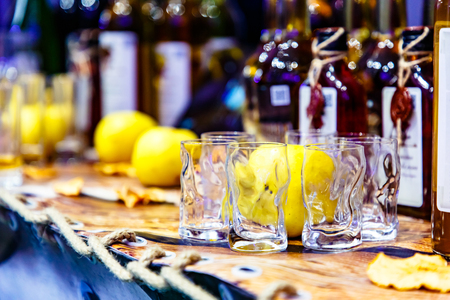 Glasses and apples are on the bar against the background of bottles.の写真素材