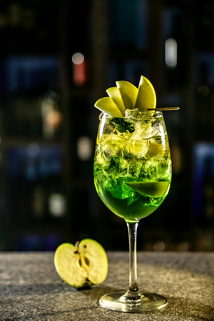 Green cocktail with Apple liqueur revolves on a black background.の写真素材