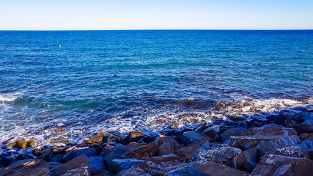 The rocky shore of the sea, the sunset in the eveningの写真素材