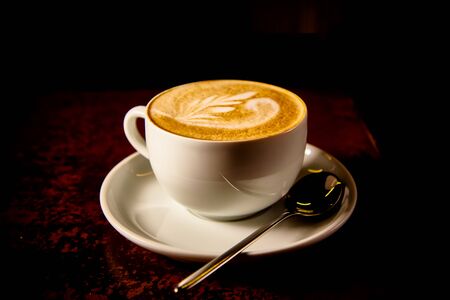 A Cup of cappuccino coffee on a dark backgroundの写真素材