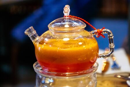 Red tea with sea buckthorn in a glass teapot.の写真素材