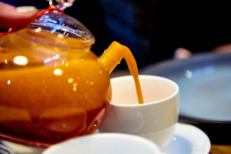 Red tea with sea buckthorn in a glass teapot.の写真素材