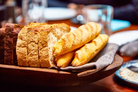 Basket with different bread on the table in the restaurantの写真素材