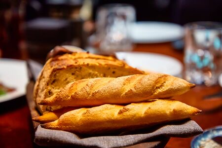 Basket with different bread on the table in the restaurantの写真素材