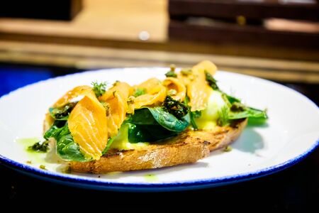 Bruschetta with salmon, spinach and poached eggの写真素材