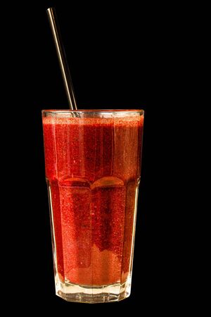 Red berry smoothie in a large glass glass on a black background, isolatedの写真素材