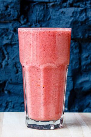 Lilac berry smoothie in a large glass glass against a stone wallの写真素材