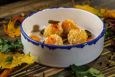 Potato croquettes with hot sauce and pepper are on a plate
