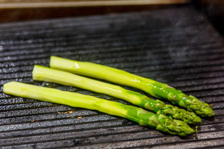 Asparagus and baguette slices are grilled in the restaurantの写真素材