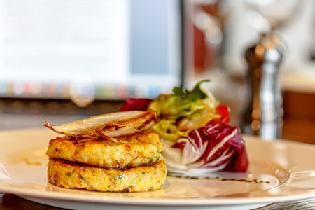 Hashbrown potato patties are served with salad on a plate. largly