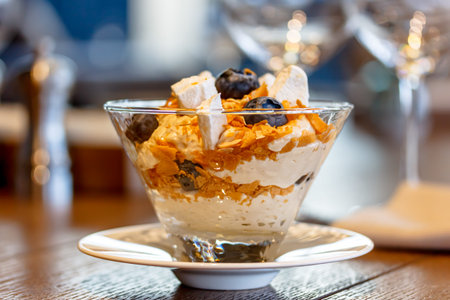 Yogurt with fruit granola and muesli is in a glass glass. Largly