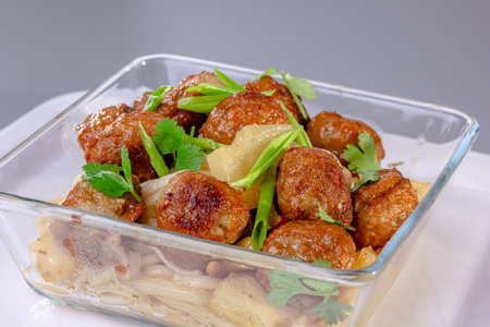 Meat balls with noodles are on a plate.