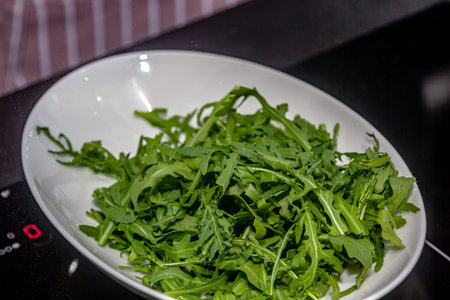 Woman holding plate with tasty arugula salad, closeup