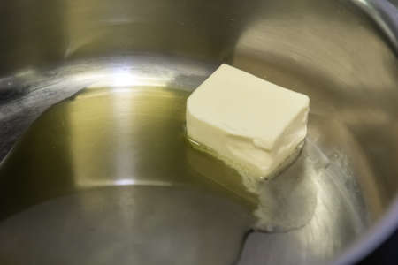 Frying pan with melting butter on wooden background.の写真素材