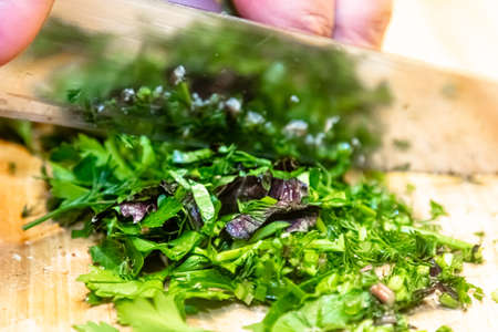 Chopped Fresh Herbs on a Bamboo Cutting Board: A pile of chopped mint, cilantro, and parsley on a wood cutting board.の写真素材
