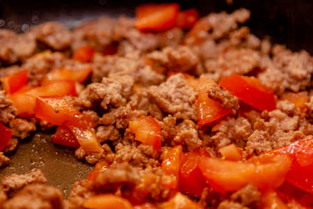Bolognese ragout in a frying pan with wooden spoon, authentic recipe, close-up.の写真素材