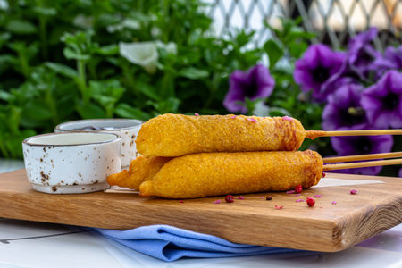 Traditional American street food corn dogs with mustard and ketchup on wooden table.top view.