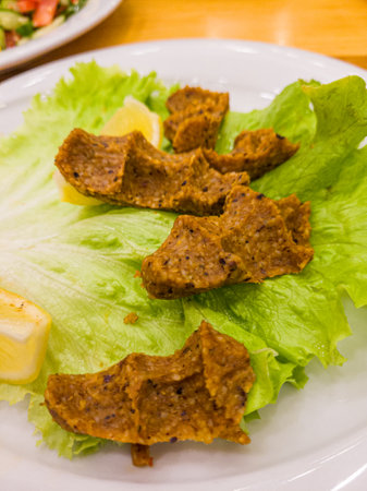 Fried pork with lettuce and lemon on white plate, Thailand.の写真素材